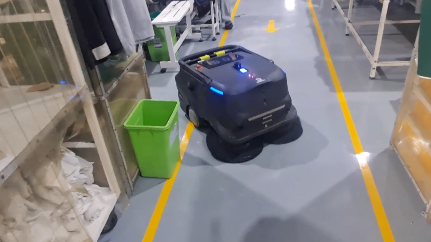 Robot PUDU MT1 chạy giữa lối đi vạch vàng trong xưởng may
